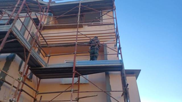 Operaio Edil POLO al lavoro sul ponteggio della facciata