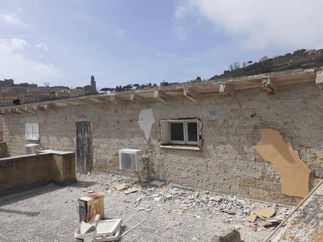 Facciata in pietra durante la rimozione dell'intonaco ammalorato