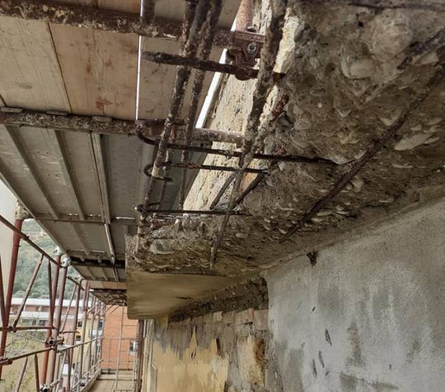 Balcone in cemento armato con ferri d'armatura scoperti durante il ripristino