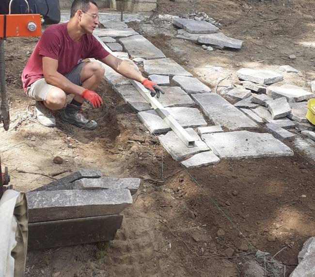 Posa di lastre in pietra per un vialetto in giardino