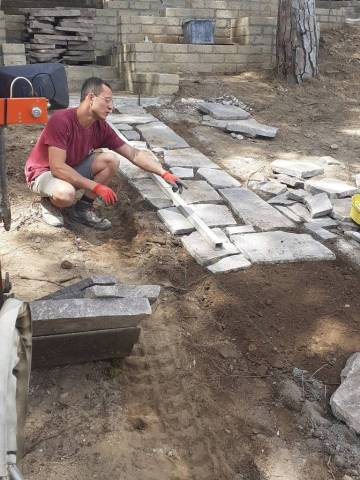 Posa di lastre in pietra per un vialetto in giardino