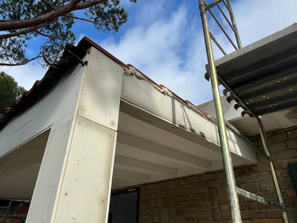 Lavori di rivestimento del cornicione di una villa, vista dal basso